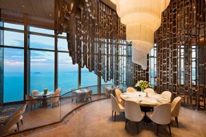 厦门Conrad Xiamen-Free Mini Bar的用餐室配有吊灯和桌椅