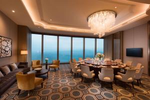 厦门Conrad Xiamen-Free Mini Bar的一间带桌椅和吊灯的用餐室