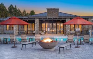 坎普维德Verde Ranch RV Resort的一个带火坑、椅子和遮阳伞的庭院