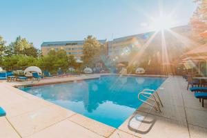 恩格尔伍德The Inverness Denver, a Hilton Golf & Spa Resort的一个带椅子和阳光的大型游泳池