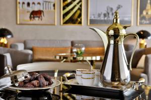 多哈多哈艾雷亚恩古玩系列希尔顿酒店的茶壶桌上的一盘食物