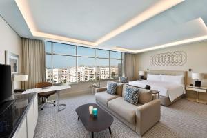 丹吉尔Hilton Tanger City Center的大型酒店客房,配有床和沙发