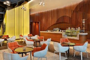 迪拜迪拜希尔顿逸林酒店 - 商务湾的一间带桌椅和柜台的餐厅