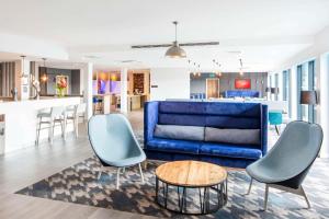 Kirmington亨伯赛德机场汉普顿希尔顿酒店的客厅配有蓝色的沙发和桌子