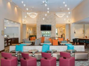 Center ValleyHomewood Suites By Hilton Allentown Bethlehem Center Valley的大堂设有等候区,配有粉红色和蓝色的椅子