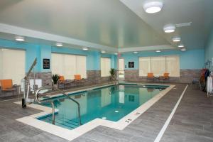 Center ValleyHomewood Suites By Hilton Allentown Bethlehem Center Valley的一座带蓝色墙壁和橙色椅子的大型游泳池