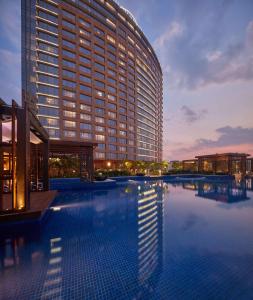 班加罗尔班加罗尔康莱德酒店的一座大型建筑,前面设有一个游泳池