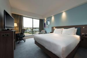 爱丁堡爱丁堡西区希尔顿汉普顿酒店的酒店客房配有一张床、一张书桌和一台电视。