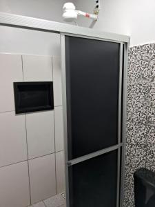 马瑙斯Alvorada Suite的带微波炉的浴室内的黑色门