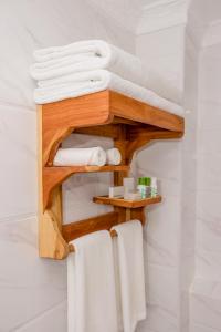 纳纽基The Glacier Hotel Nanyuki的浴室设有木制架子和毛巾