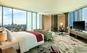 泗水DoubleTree by Hilton Surabaya的酒店客房设有一张床和一张带显示器的书桌
