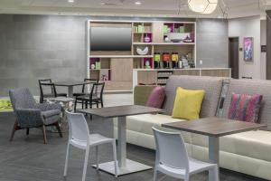 奥兰多Home2 Suites By Hilton Orlando Airport的带沙发和桌椅的等候室