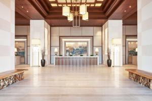 迪拜迪拜希尔顿艾尔哈布图尔城酒店的大房间设有大堂,配有桌子和长凳
