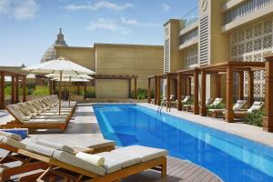 迪拜迪拜希尔顿艾尔哈布图尔城酒店的一座带躺椅的游泳池和一座建筑