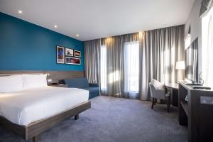 蒂斯河畔斯托克顿Hampton By Hilton Stockton On Tees的酒店客房,设有床铺和蓝色的墙壁