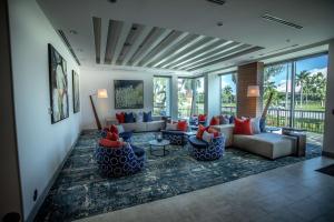 西棕榈滩Hilton Garden Inn West Palm Beach I95 Outlets的带沙发和椅子的客厅以及窗户。