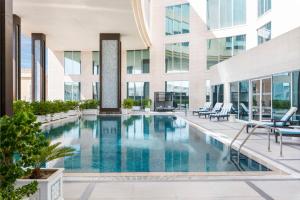 多哈Doubletree By Hilton Doha - Al Sadd的一座建筑物中央的游泳池