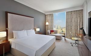 多哈Doubletree By Hilton Doha - Al Sadd的一间设有大床和窗户的酒店客房