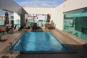 维多利亚Praia do Canto Apart Hotel - Apto 405 - Varanda Lateral com Vista Mar的建筑物屋顶上的游泳池