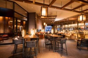 新加坡Conrad Centennial Singapore的一间带桌椅的餐厅和一间酒吧