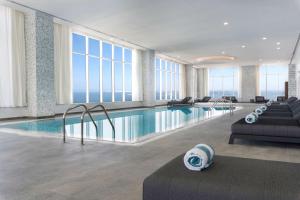 多哈Aleph Doha Residences, Curio Collection By Hilton的酒店大堂设有窗户游泳池
