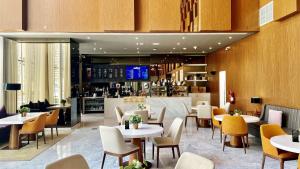 多哈Aleph Doha Residences, Curio Collection By Hilton的一间带桌椅的餐厅和一间酒吧