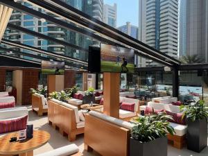 多哈Aleph Doha Residences, Curio Collection By Hilton的一间带桌椅和电视的餐厅