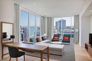 多哈Aleph Doha Residences, Curio Collection By Hilton的带沙发和大窗户的客厅