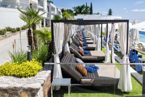 里耶卡Hilton Rijeka Costabella Beach Resort And Spa的海滩上的一排躺椅