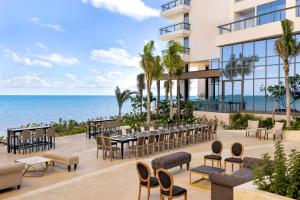 坎昆Hilton Cancun, an All-Inclusive Resort的一个带桌椅的户外庭院和大海