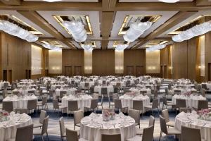 阿布扎比Hilton Abu Dhabi Yas Island的一个带白色桌椅的大型宴会厅