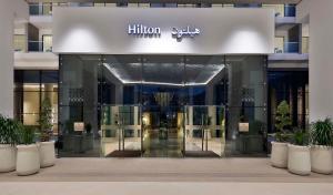 阿布扎比Hilton Abu Dhabi Yas Island的建筑物入口,上面有hiltonume标志