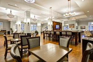 查尔斯顿Hampton Inn & Suites Charleston Airport的一间带桌椅的餐厅和一间酒吧