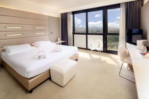 博洛尼亚塔博洛尼亚贝斯特韦斯特优质酒店的卧室设有白色的床和大窗户