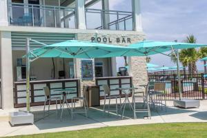 默特尔比奇DoubleTree Resort by Hilton Myrtle Beach Oceanfront的一个带桌椅和遮阳伞的池畔酒吧