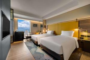 台北台北时代寓所-希尔顿启缤精选酒店的酒店客房设有两张床和电视。
