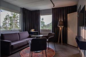 鲁卡斯堪的克卢卡霍维旅馆的客厅配有沙发、桌子和两把椅子
