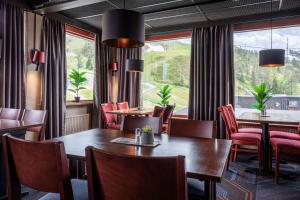 鲁卡斯堪的克卢卡霍维旅馆的一间带桌椅的用餐室和大窗户