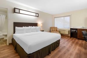 赫斯特Villa Inn & Suites - SureStay Collection by Best Western的酒店客房设有一张大床和一间浴室。