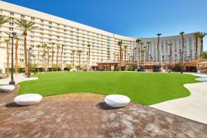 拉斯维加斯Virgin Hotels Las Vegas, Curio Collection by Hilton的一座大建筑,在一座建筑前有一座绿色庭院