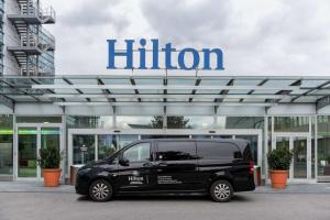 日内瓦Hilton Geneva Hotel and Conference Centre的停在黑尔顿商行前面的一辆黑色货车