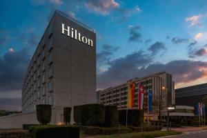 日内瓦Hilton Geneva Hotel and Conference Centre的一座建筑的侧面有hilton标志