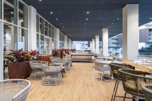 棕榈滩Embassy Suites By Hilton Aruba Beach Resort的一间带桌椅的餐厅和一间酒吧