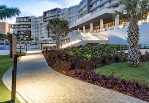 棕榈滩Embassy Suites By Hilton Aruba Beach Resort的棕榈树建筑前的走道