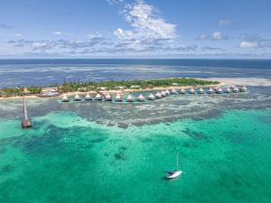 伊洛特梅特内DoubleTree by Hilton Noumea Ilot Maitre Resort的水中有一个带遮阳伞和船只的岛屿