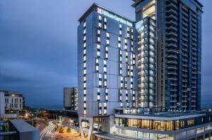 德班Hilton Garden Inn Umhlanga Arch的一座高大的蓝色建筑,灯火通明