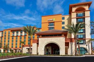 奥兰多Home2 Suites By Hilton Orlando Flamingo Crossings, FL的棕榈树酒店前的 ⁇ 染
