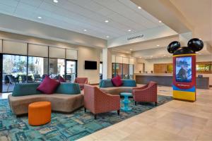奥兰多Home2 Suites By Hilton Orlando Flamingo Crossings, FL的酒店大堂设有长沙发和椅子。