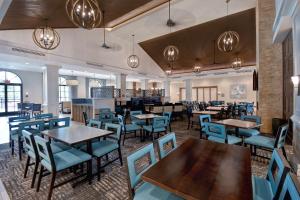 奥兰多Homewood Suites By Hilton Orlando Flamingo Crossings, Fl的一间配备有桌子和蓝色椅子的用餐室