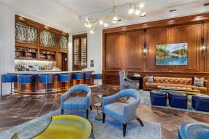 查尔斯顿Hilton Club Liberty Place Charleston的一间酒吧,里面摆放着蓝色的椅子和沙发
